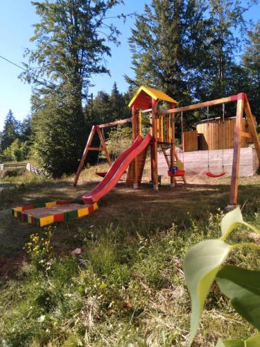 a park with a playground with a slide at Casa din Poiană in Hănăşeşti