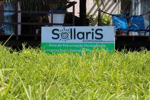 a sign in the middle of a field of grass at Sollaris Ecopousada in Japaratinga