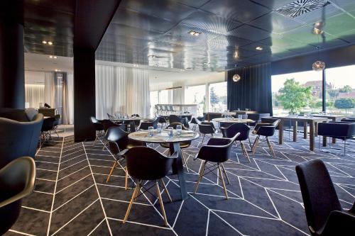 a restaurant with tables and chairs and windows at Novotel Katowice Centrum in Katowice