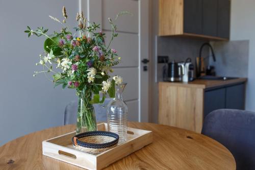 wazon kwiatów siedzący na drewnianym stole w obiekcie Agroturystyka Pod Dębem w Łagowie
