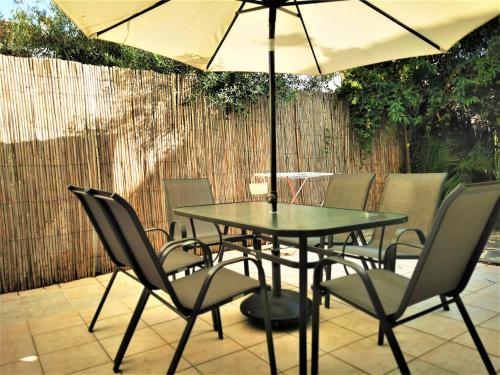 a table and chairs with an umbrella on a patio at Casa Mameli Αpartments in Kallithea Halkidikis