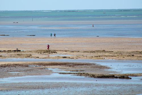 a beach with people walking on the sand and water at Sollaris Ecopousada in Japaratinga