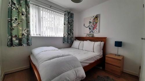 a small bedroom with a bed and a window at 2 bedroom Chalet all to yourself, free parking, dogs welcome in Swansea