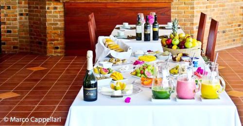 a long table with plates of food and bottles of wine at Hotel & Pousada Tatajuba in Canoa Quebrada