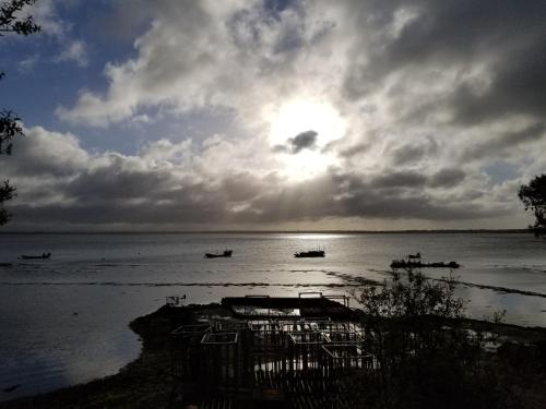 a group of boats in the water under a cloudy sky at AMARRÉ Chambres d'Hôtes in Sarzeau