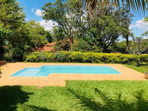 a small blue swimming pool in a yard at Chácara em Brotas in Brotas