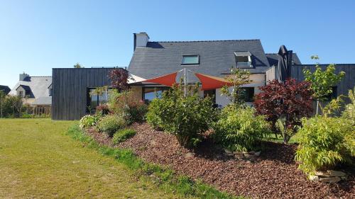 a house with a row of plants in a yard at AMARRÉ Chambres d'Hôtes in Sarzeau