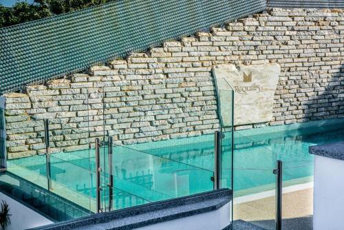 a glass swimming pool with a brick wall at Apartamento Rural Requies in Feria