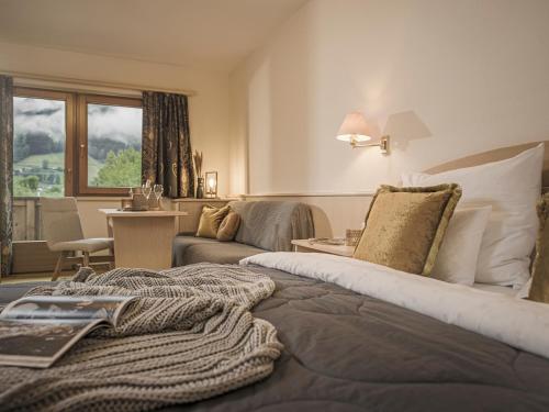 a hotel room with a bed and a living room at Hotel Post in Kaltenbach