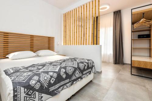 a bedroom with a bed with a black and white blanket at Golden Beach Hotel in Chrissi Akti
