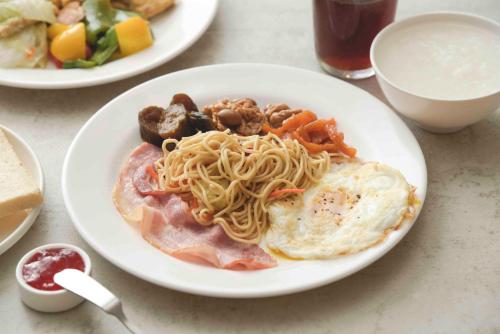 a plate of food with pasta and eggs on a table at Kending Kaying Hotel in Hengchun
