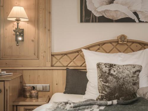 a bedroom with a bed with a wooden headboard at Hotel Post in Kaltenbach