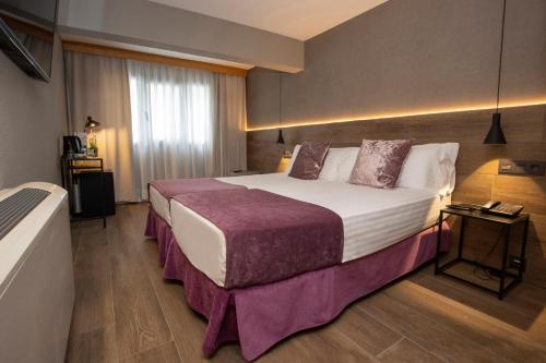 a hotel room with a large bed with purple sheets at Yomo Eureka in Andorra la Vella
