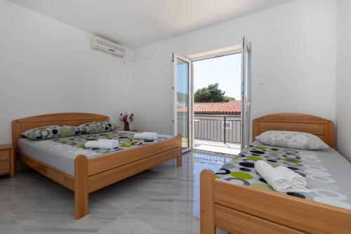 two beds in a bedroom with a balcony at Villa Ševo Baška Voda in Baška Voda