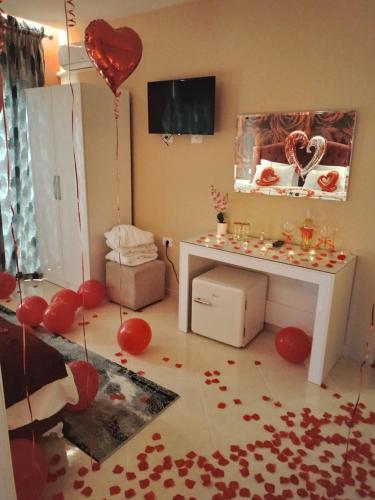 - un salon avec des coeurs rouges au sol et une table dans l'établissement Ajilin Hotel Rooms, à Korçë