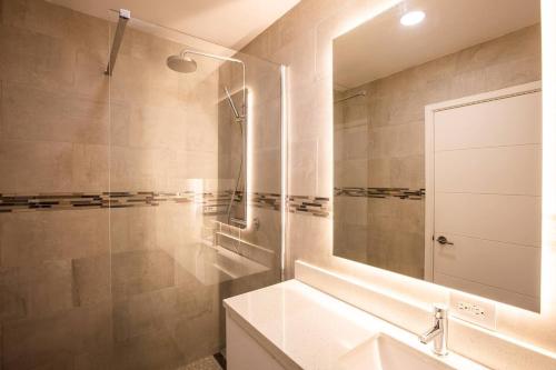 a bathroom with a sink and a shower with a mirror at Garden View Condo in Maho in Maho Reef