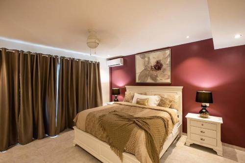 una camera da letto con pareti viola, un letto e un comodino di Garden View Condo in Maho a Maho Reef