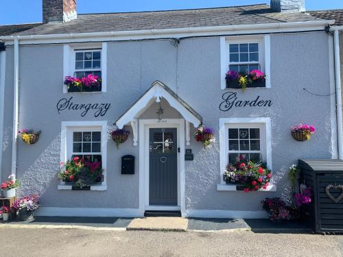 una casa azul con flores en las ventanas en Stargazy Garden, en Hayle