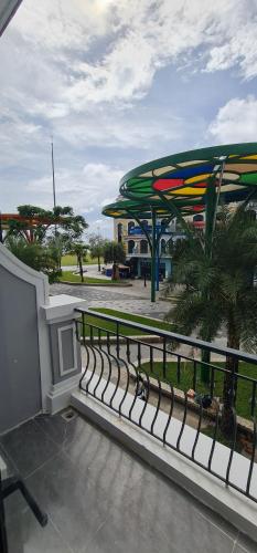 a fence in front of a park with a umbrella at BREAKING DAWN- TAEYANG Hotel Phú Quốc in Phu Quoc