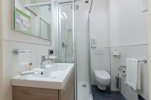 a bathroom with a sink and a shower and a toilet at Hotel Suisse in Marina di Pietrasanta