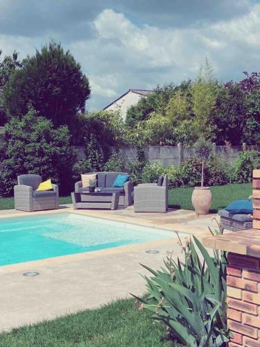 - une piscine avec des canapés et des chaises à côté d'une cour dans l'établissement Très joli appartement équipé au calme, à Rozay-en-Brie