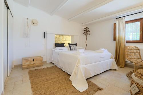 a white bedroom with two beds and a window at Trullo Natù in Alberobello