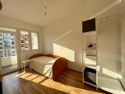 a bedroom with a bed and a book shelf at Sara's Apartment Cozy and Close to Center with Private Parking in Skopje