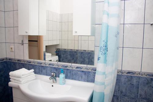 een badkamer met een wastafel en een spiegel bij Apartment Leatoni in Split