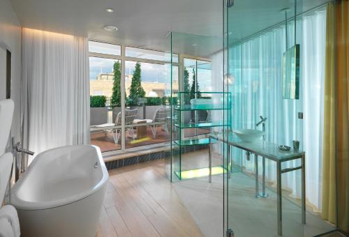 a bathroom with a tub and a glass shower at Sanderson London in London