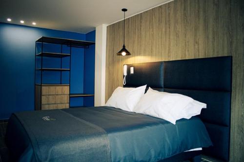 a blue bedroom with a bed with a blue wall at Estainn Hotel Coworking in Bogotá