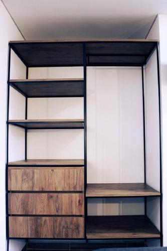 a closet with wooden shelving and glass shelves at Estainn Hotel Coworking in Bogotá