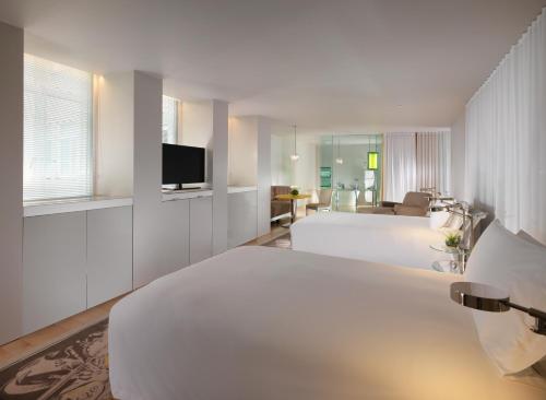 ein Hotelzimmer mit 2 Betten und einem TV in der Unterkunft Sanderson London in London