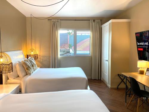 a hotel room with two beds and a window at Magnolia Inn in Panama City