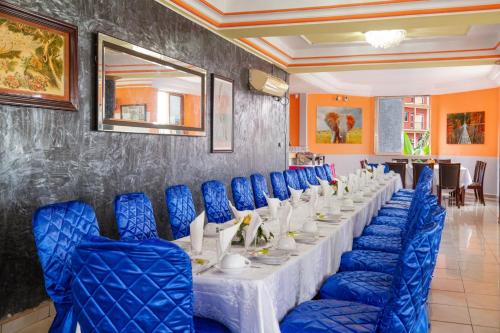 a long table with blue chairs in a room at FELICIA HOTEL YAOUNDE in Yaoundé