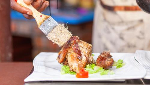 a person holding a wooden spatulaacistacistangering at FELICIA HOTEL YAOUNDE in Yaoundé