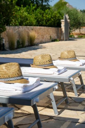 three picnic tables with hats sitting on top of them at Trullo Natù - private villa in Alberobello