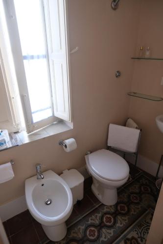 a bathroom with a toilet and a sink and a window at Marianna in Isnello