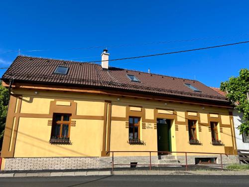 ein gelbes Gebäude mit braunem Dach in der Unterkunft Vila Liberta in Poprad