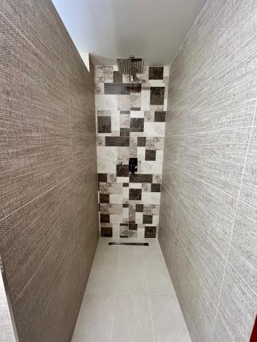 a walk in shower with a tile wall at Vila Liberta in Poprad