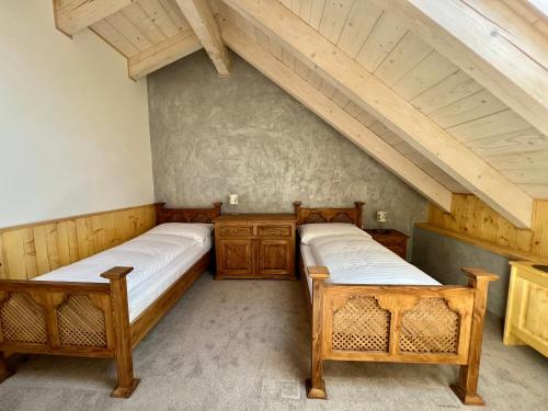 two beds in a room with an attic at Vila Liberta in Poprad