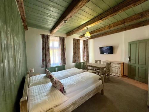 a bedroom with two beds and a table and a television at Vila Liberta in Poprad