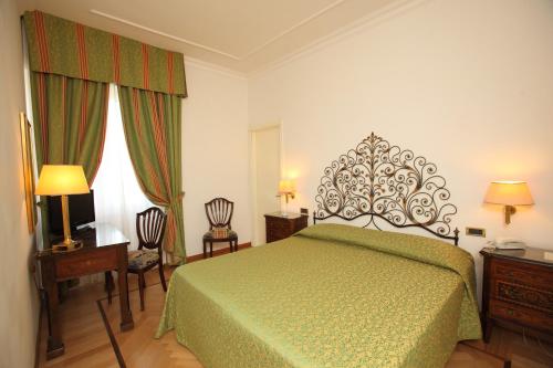 a bedroom with a green bed and two chairs at Grand Hotel Villa Balbi in Sestri Levante
