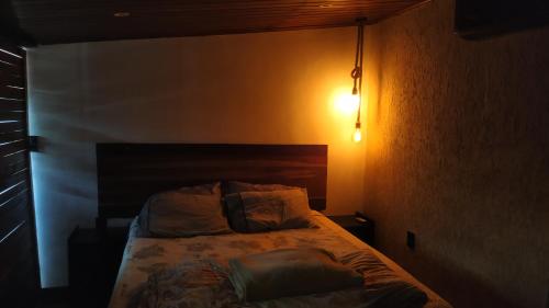 a bedroom with a bed in a dark room at Loft Antunes in Maricá