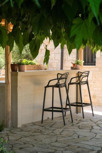 two chairs sitting next to a table with plants at Trullo Natù - private villa in Alberobello