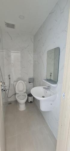 a white bathroom with a toilet and a sink at BREAKING DAWN- TAEYANG Hotel Phú Quốc in Phu Quoc