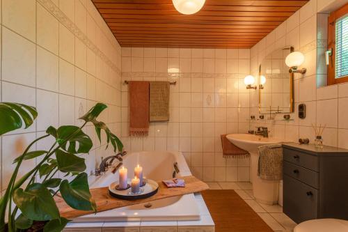 a bathroom with a bath tub and a sink at Blockhaus Eifelsteig w/ Kamin Garten & Feuerstelle in Berndorf