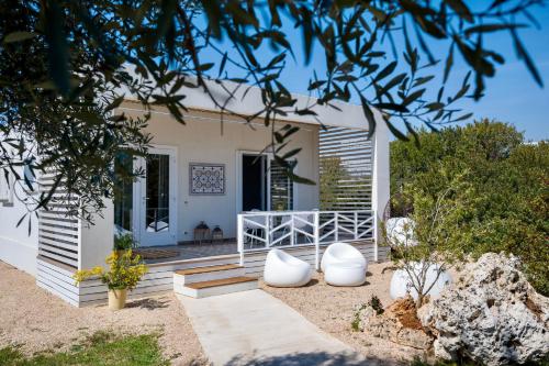 a house on the beach with a porch at Macchia Piccinna in Maruggio