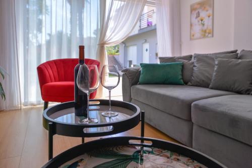 uma sala de estar com um sofá e uma mesa com copos de vinho em Apartments Danijela & Love Nest em Rijeka