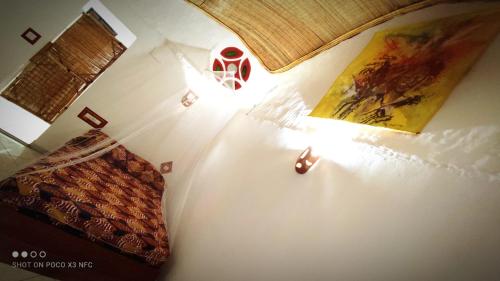 una camera da letto con un letto e una lampada sul muro di NaturUbuntu a Kafountine