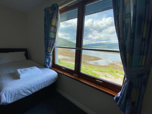 a bedroom with a bed and a window with a view at Waterfront Lodge - Accommodation Only in Fort William
